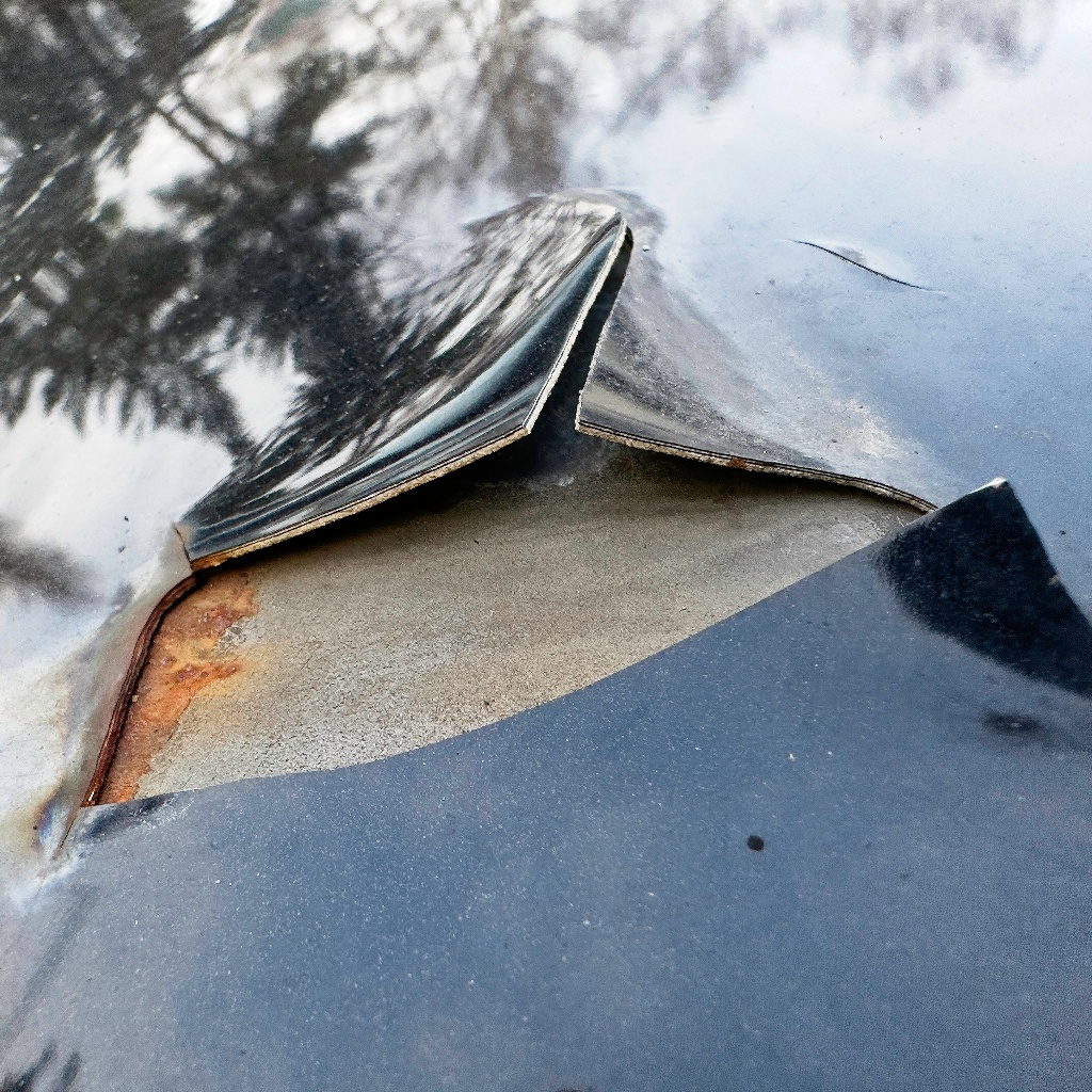 repaired vehicle after aging, thick putty plus coating layers are flaking off the hood